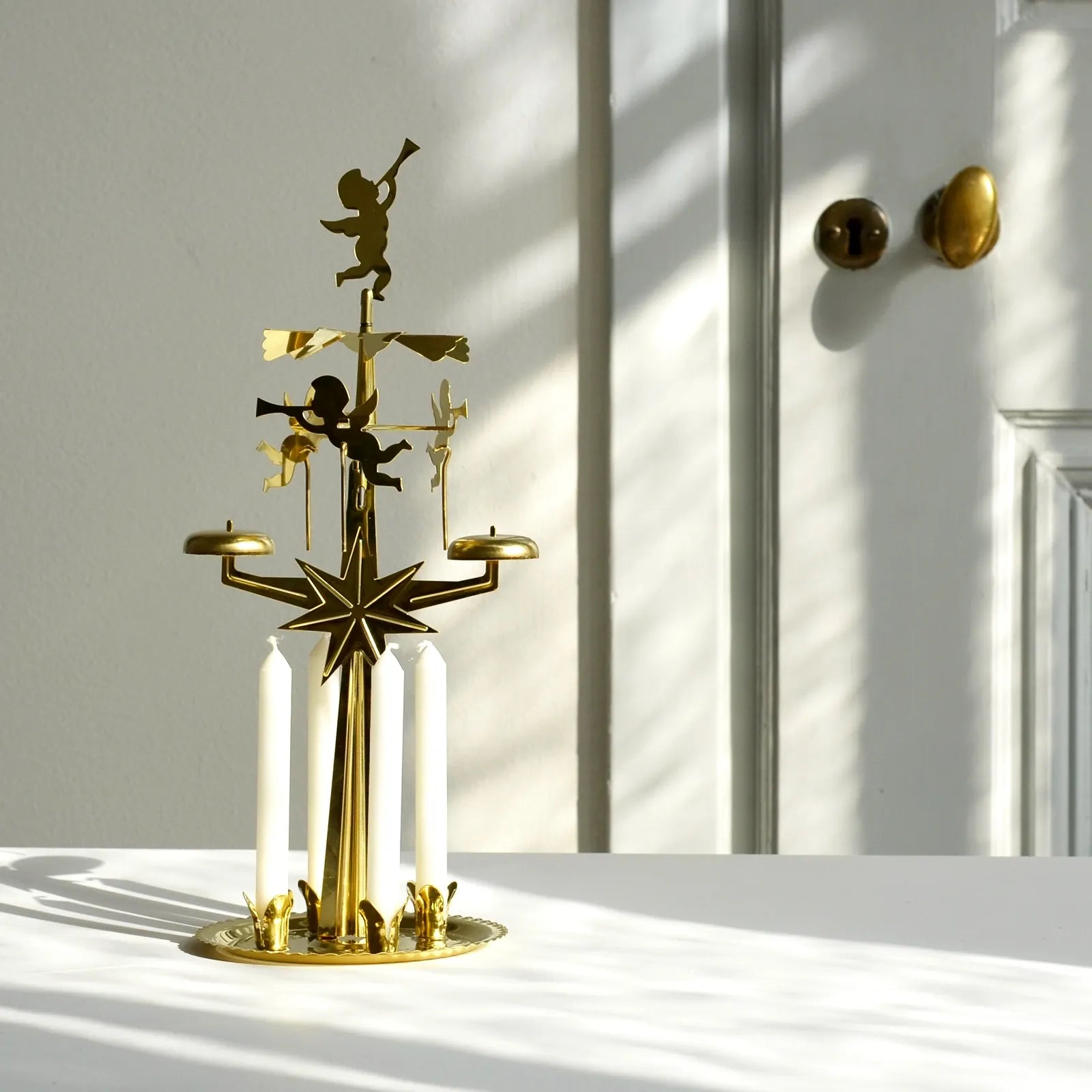 anglaspel-som-star-pa-ett-bord-med-ljus-som-kommer-in-fran-hoger-sida-och-skapar-ett-skuggspel-pa-bordet