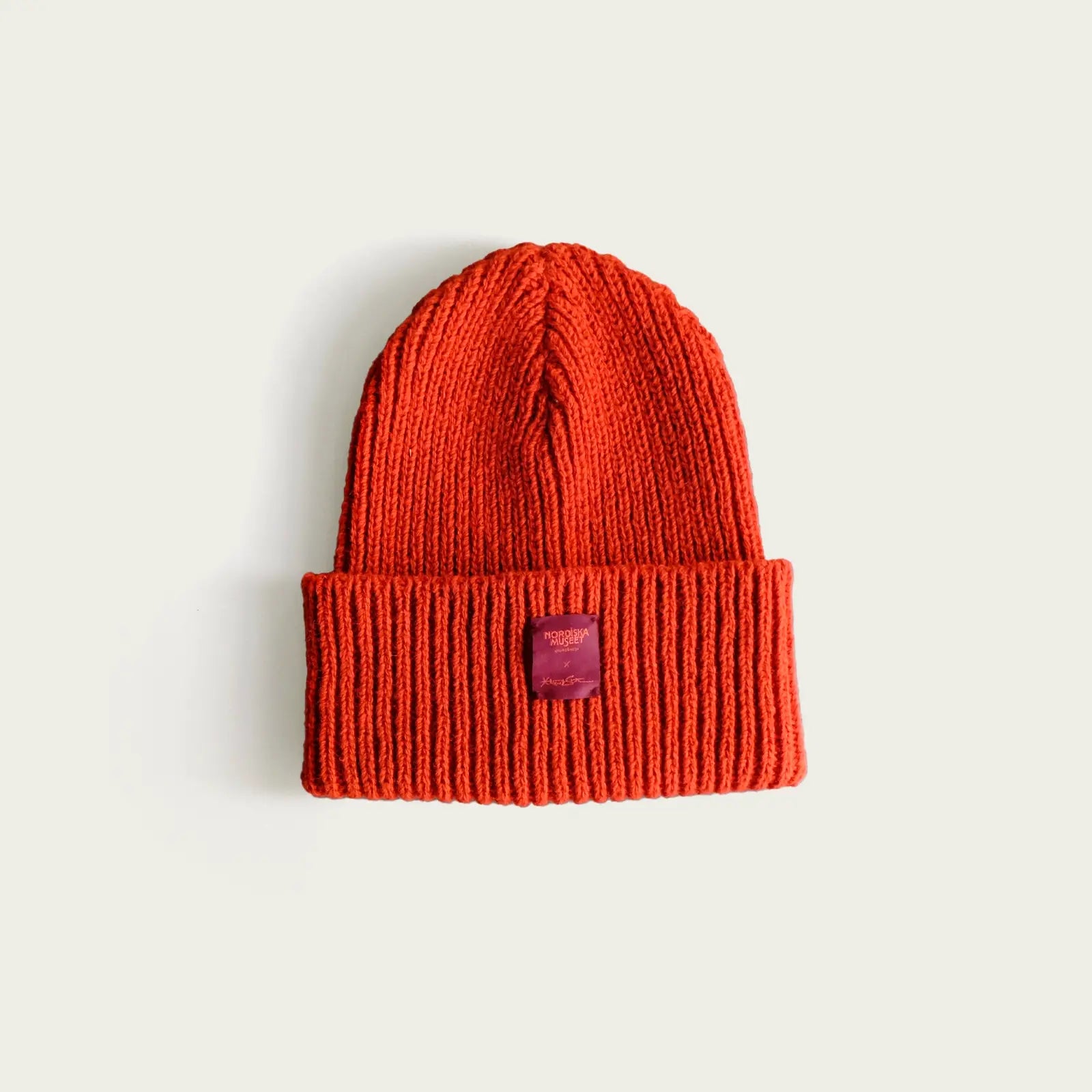 brandrod-stickad-mossa-med-label-nordisk-museet-och-alexander-stutterheim