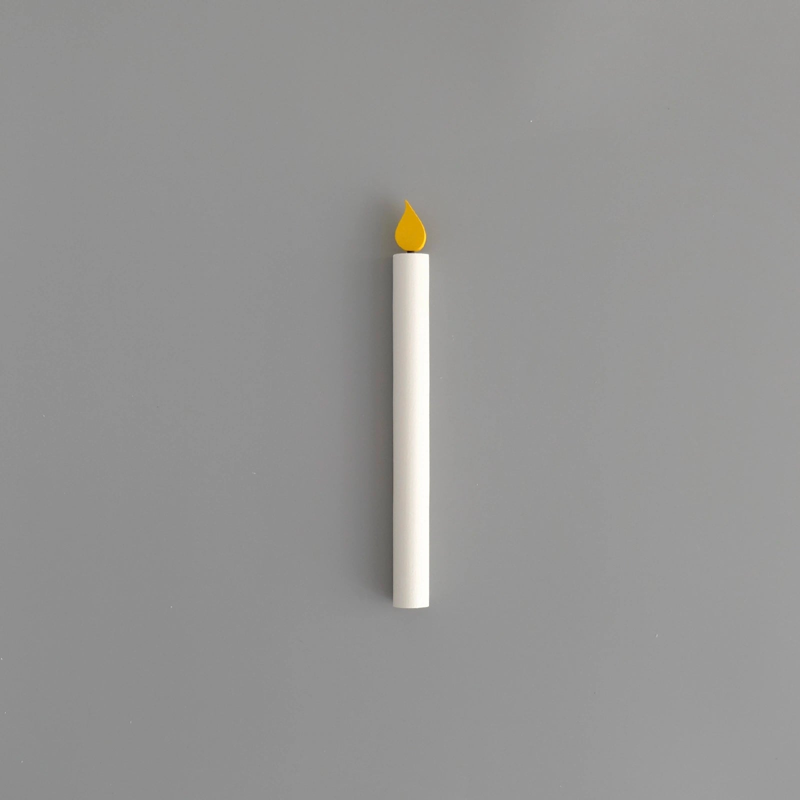 ett-vitt-ljus-helt-i-tra-med-en-gulmalad-laga