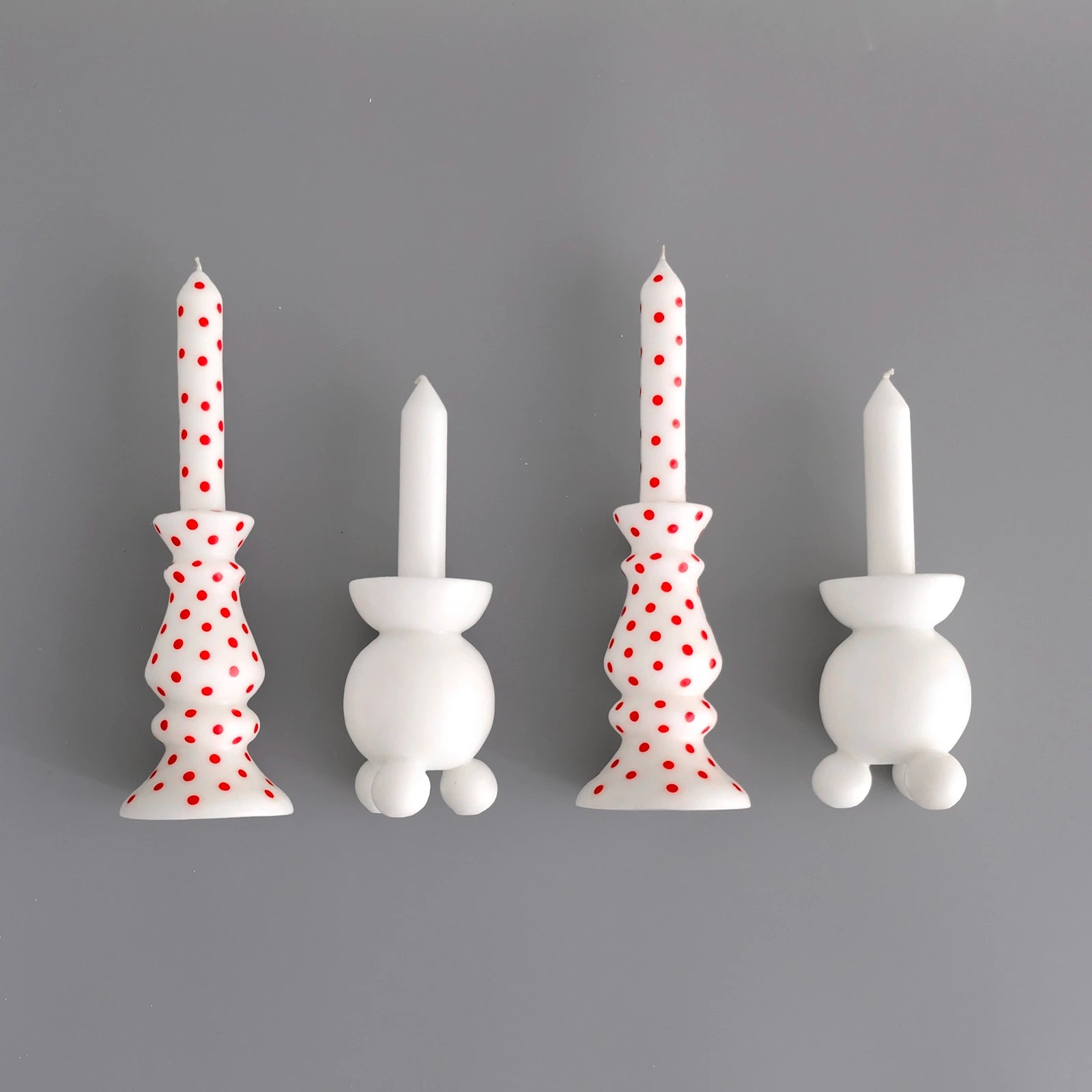 fyra-blockljus-pa-rad-pa-en-gra-bakgrund-tva-ljus-ar-rodprickiga-och-de-tva-andra-vita