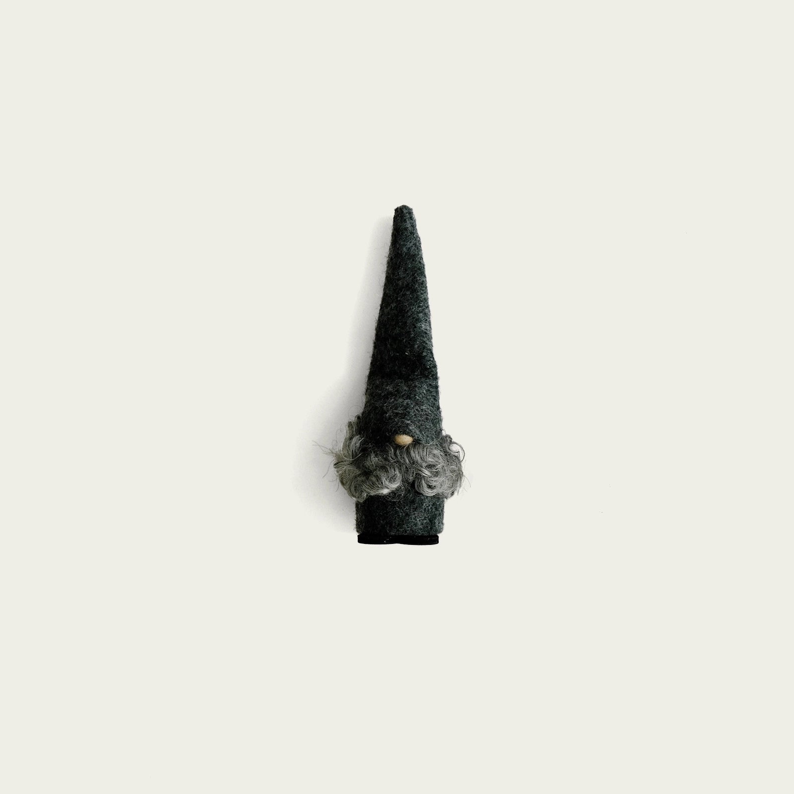 gra-tomte-i-ull-med-liten-tranasa-som-sticker-fram-under-tomteluvan