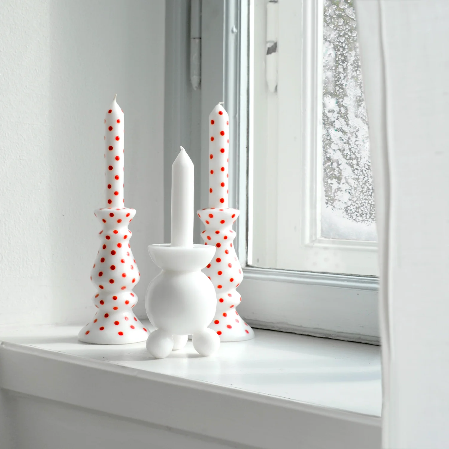 tre-ljus-pa-ett-fonsterbrade-det-snoar-utanfor